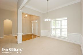 Dallas house for rent - A spacious room with a large window and a door in the background.