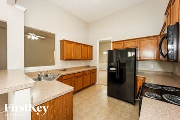 Dallas house for rent - A kitchen with wooden cabinets and black appliances.
