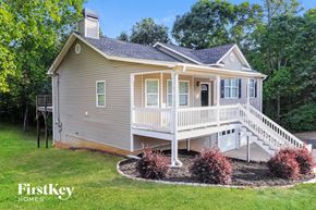Dallas house for rent - A house with a grey siding and a white porch.
