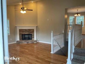 Dallas house for rent - A living room with a fireplace and a ceiling fan.