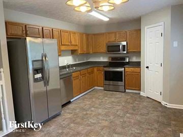 Dallas house for rent - A kitchen with a refrigerator, oven, microwave, and stove.
