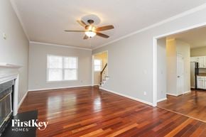 Greensboro house for rent - the living room and dining room with wood floors and a ceiling fan