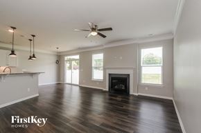 Mooresville house for rent - A spacious living room with a fireplace and a ceiling fan.