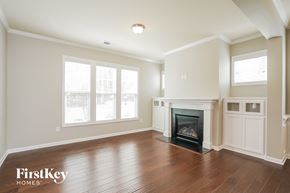 Clayton house for rent - A spacious living room with a fireplace and wood flooring.