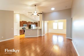 Summerville house for rent - an empty living room with a kitchen and a ceiling fan