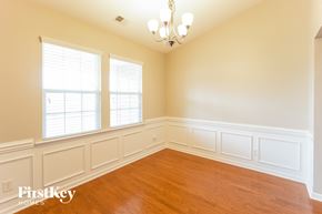 Summerville house for rent - a dining room with white walls and wood floors and a chandelier
