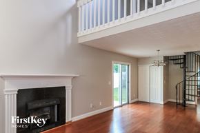 Alpharetta house for rent - A well-lit room with a fireplace and a staircase.