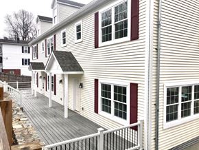 Peekskill apartment for rent - a white house with red shutters and a wooden deck