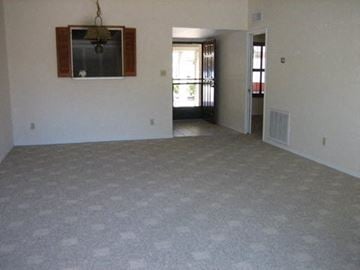 Phoenix house for rent - an empty living room with a tv on the wall