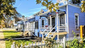 Lafayette apartment for rent - a row of blue houses with stairs and a white fence