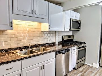 Lafayette apartment for rent - an empty kitchen with white cabinets and granite counter tops