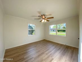 Carencro house for rent - an empty living room with a ceiling fan and a window