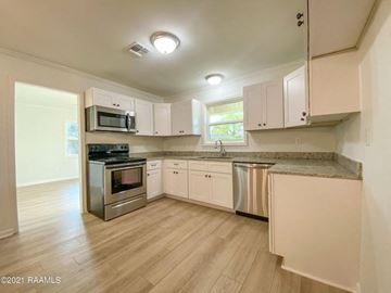 Carencro house for rent - a kitchen with stainless steel appliances and white cabinets