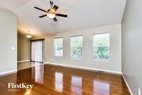 Fenton house for rent - an empty living room with wood floors and a ceiling fan