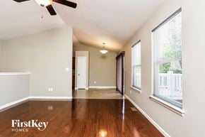 Fenton house for rent - an empty living room with wood flooring and large windows