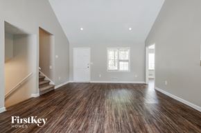 Suwanee house for rent - the living room and entryway of a new home with wood floors and white walls