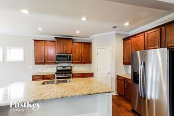 Gainesville house for rent - A kitchen with wooden cabinets and a granite countertop.