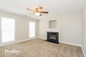 Winston-Salem house for rent - A room with a fireplace and a ceiling fan.
