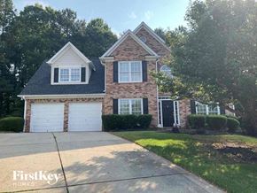 Dallas house for rent - a brick house with white garage doors and a driveway
