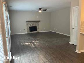 Dallas house for rent - an empty living room with wood floors and a fireplace