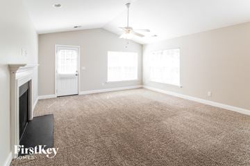 Goose Creek house for rent - A living room with a carpet floor and a ceiling fan.