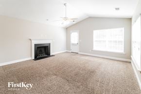 Goose Creek house for rent - A spacious room with a fireplace and a ceiling fan.