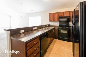 Goose Creek house for rent - A kitchen with a black refrigerator and brown cabinets.