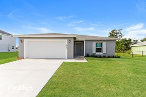 Port St. Lucie house for rent - A house with a garage and a fence in the front yard.