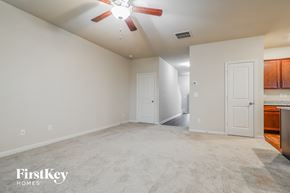 Pendergrass house for rent - A spacious room with a ceiling fan and a kitchen area in the background.