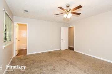 Acworth house for rent - a living room with carpet and a ceiling fan