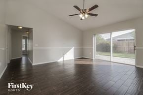 Orlando house for rent - A spacious room with a ceiling fan and wooden flooring.