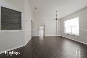 Orlando house for rent - A spacious room with wooden floors and a chandelier.