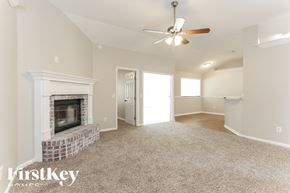 Orange Park house for rent - A spacious living room with a fireplace and a ceiling fan.