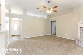 Orange Park house for rent - A spacious room with a ceiling fan and beige walls.
