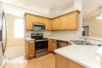 Orange Park house for rent - A kitchen with wooden cabinets and a white countertop.