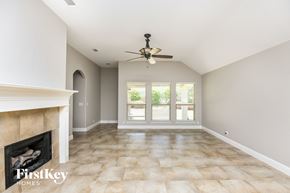 Burleson house for rent - a living room with a fireplace and a ceiling fan