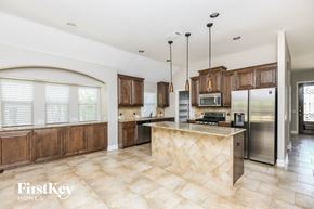 Burleson house for rent - a kitchen with wooden cabinets and a marble counter top