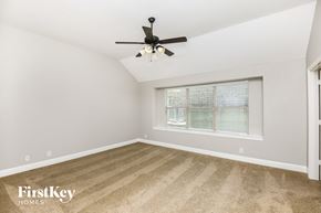 Burleson house for rent - a bedroom with a ceiling fan and a window
