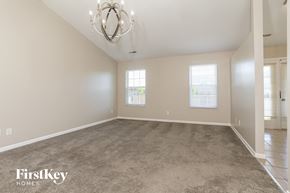 Trenton house for rent - an empty living room with carpet and a chandelier