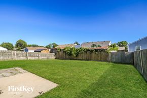 Trenton house for rent - a backyard with a grass lawn and a wooden fence