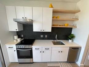 Asheville apartment for rent - A modern kitchen with white cabinets and black countertops.