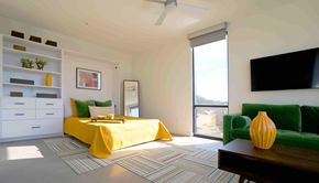 Asheville apartment for rent - A bedroom with a yellow bed and a green couch.