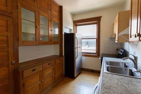 Detroit apartment for rent - A kitchen with wooden cabinets and a black refrigerator.