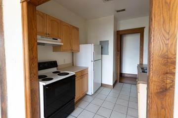 Detroit apartment for rent - A kitchen with a black stove top oven and a white refrigerator.