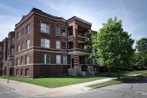Detroit apartment for rent - A large red brick building with a tree in front of it.