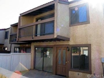 Fontana house for rent - a building with a balcony and a glass door