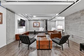 Victoria apartment for rent - A modern living room with a wooden floor and black chairs.