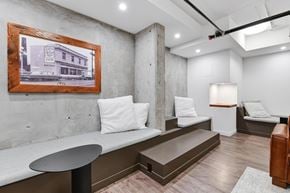 Victoria apartment for rent - A room with a framed picture of a building on the wall and a bench with a cushion on it.