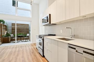 Victoria apartment for rent - A modern kitchen with white cabinets and stainless steel appliances.