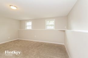 Charlotte house for rent - a bedroom with a carpeted floor and two windows